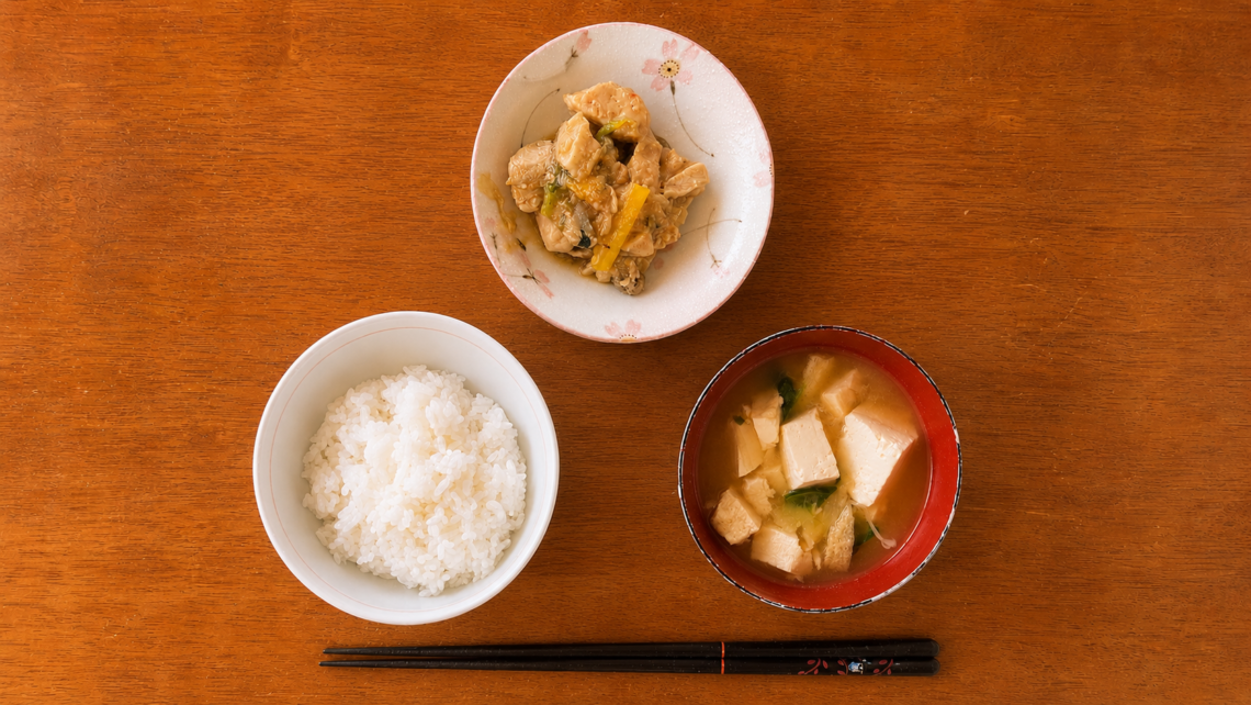白ごはん、鶏肉と野菜の黒酢あんかけ、具だくさん塩麹オイスター辛味噌汁を並べた本日のまかない